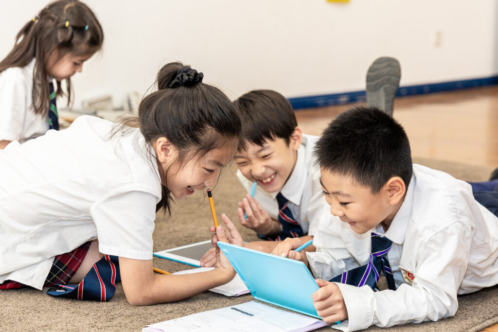 Kids laughing and doing homework.
